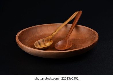 Two Wooden Spoon on Plate With Black Background  - Shutterstock ID 2231360501
