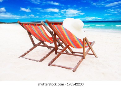  Two wooden sun loungers on white sand