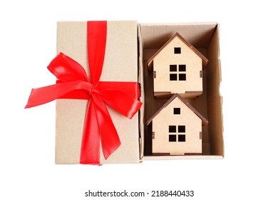 Two Wooden Toy Houses Inside A Small Shipping Box With A Red Ribbon Bow. Creative Real Estate Deal Concept.