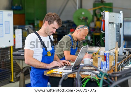 two worker in factory on work bench