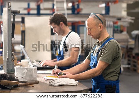 two worker in factory on work bench