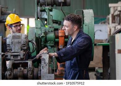 Two Workers At An Industrial Plant. Working Together Manufacturing Activities.. Worker And Engineer Under Inspection And Checking Production Process On Factory