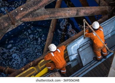 Two workers at jack up oil rig leg when checking everything in rig move operation - Shutterstock ID 369506348