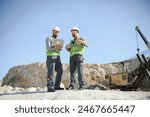 Two workers and quarry in background.