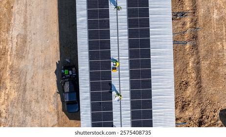 Two workers in safety gear installing solar panels on a rooftop, highlighting renewable energy, sustainability, and the integration of skilled labor in setting up efficient solar power systems.