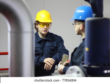 Two workers talking in a factory - Powered by Shutterstock