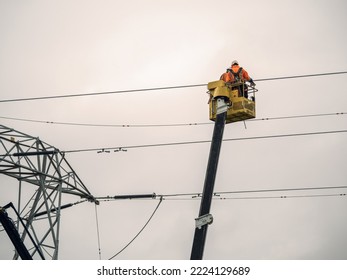 Two Workers In Telescopic Boom Lift Repair Power Line.