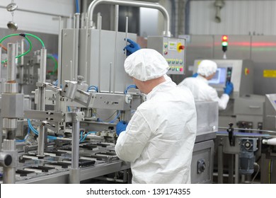 two workers in uniforms at production line in plant