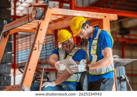 Two workers in a warehouse are using a tablet to check inventory.