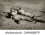 Two World War 2 era soldiers on the ground shooting