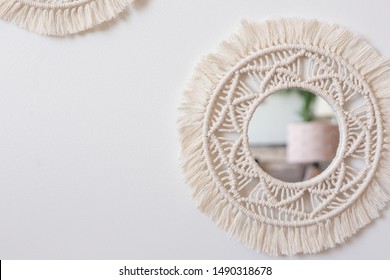 Two woven macrame mirrors on a white wall