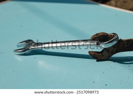 two wrenches with different textures. rusty and unrusted bolt openers are compared into one. the difference between unrusted and rusty iron on a light blue background, high angle