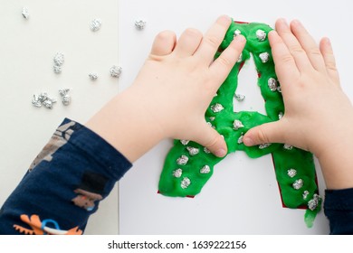 Two Year Boy Decorating Play Dough Letter 