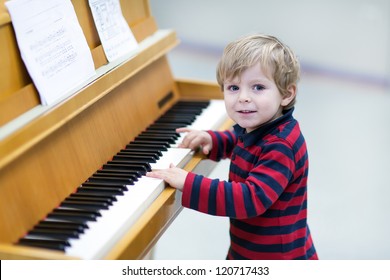 Two Years Old Happy Toddler Boy Playing Piano At Music School