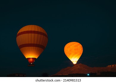 Two yellow balloons illuminated by flame torches flying in the air in the luxor egypt area. Early morning sunrise, amazing view of the huge balloons