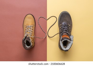 Two yellow and brown men's and women's winter suede leather stylish boots on color background. Laces in heart shape. Casual trendy footwear, shopping, sale, shoes fashion concept. Flat lay, top view