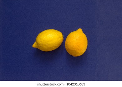 Two Yellow Lemons On A Blue Felt. The Opposite Color Of Objects Come Together In One Simple Still Life