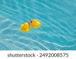 Two yellow rubber ducks in a pool