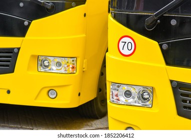 Two Yellow School Buses And A Speed Limit Sign (70 Kilometers)