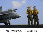 Two "Yellow Shirt" Aircraft Directors Stand in Front of an F/A-18C Hornet on the Nuclear Aircraft Carrier, USS Enterprise
