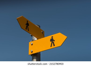 Two yellow signposts with walking figures and arrows point in different directions, Canton Thurgau, Switzerland