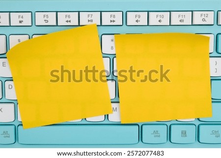 Two yellow sticky notes placed on a computer keyboard. Perfect for reminders, office work, or creative note-taking.