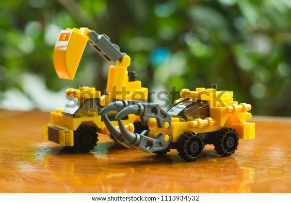 Two yellow toy\
construction vehicles