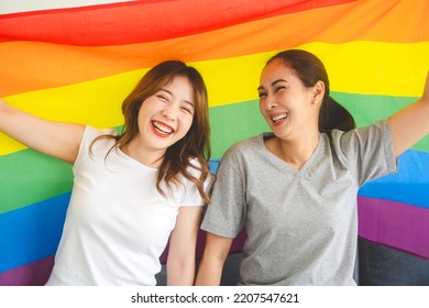 Two Young Adult Woman Living Together With Relationship Concept. Portrait Of Happy Smile Southeast Asian People Lgbt Couple With Rainbow Pride Flag. Life Moments At Home.