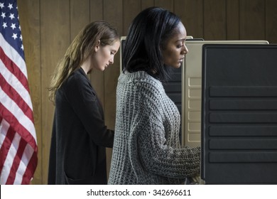 Two Young Adult Women Voting In A Voting Booth