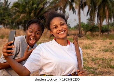two young african female farmers with phone in the farm