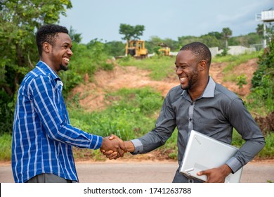 two young african modern farmers shake hands, satisfied with a deal