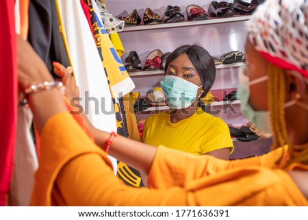 two young african women shopping for clothes in a local shop