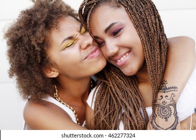 Two young afro girls having fun together, joy, positive, love, friendship, sisters. Happy meeting of two friends hugging in the street - Powered by Shutterstock