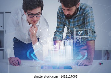 Two young architects looking at tablet with HUD virtual city interface. Concept of urban planning and hi tech. Toned image double exposure - Powered by Shutterstock