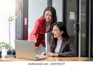Two Young Asian businesswoman discuss with new startup project Idea presentation, analyze planning and financial statistics and investment market at office.