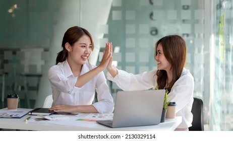 Two Young Asian Businesswoman Smiling Happy Giving High Five At The Office. Young Asian Woman Or Intern Who Successfully Completes Her Goals.