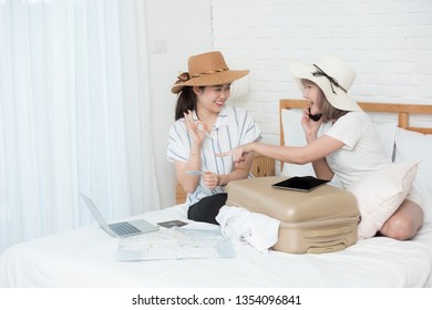 Two Young Asian Girls Preparing For Travel Vacation By Use Laptop And Tablet And Paid By Credit Card For Booking Tour.online Booking Or Online Commercial Concept.