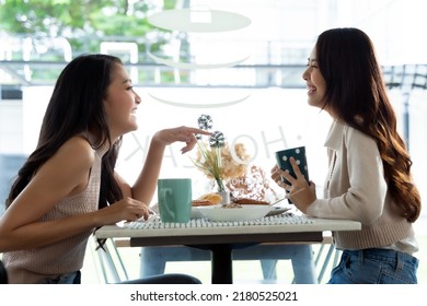 Two Young Asian Women Friends Talking At A Coffee Shop
