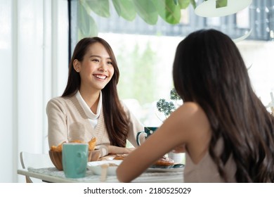 Two Young Asian Women Friends Talking At A Coffee Shop