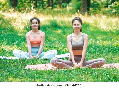 Two Young Asian Women Practicing Yoga Outdoors. Full Length. Meditation To Achieve Inner Harmony And Balance.