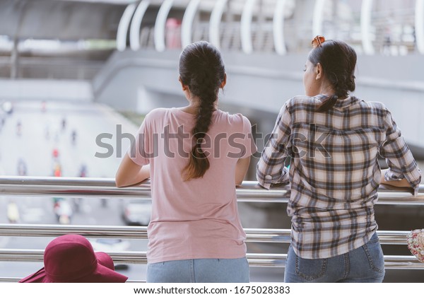 Two Young Asian women are Worried Virus outbreak\
or about the weather and pollution in the capital Since there no\
health, life protection equipment. City air pollution affects\
health, tourism concept