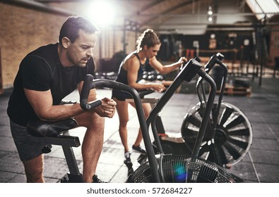 Two young athletic people in sportswear training in gym on bodybuilders. 