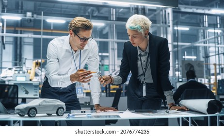 Two Young Automotive Engineers Working in Office at Car Factory. Industrial Designer and Colleague Discussing Different Applications of a Metal Pinion Gear in Personal Mobility Vehicles. - Shutterstock ID 2076774235