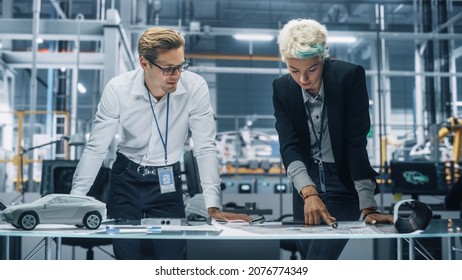 Two Young Automotive Engineers Working in Office at Car Factory. Industrial Designer and Colleague Discussing Different Applications of a Metal Pinion Gear in Personal Mobility Vehicles. - Shutterstock ID 2076774349