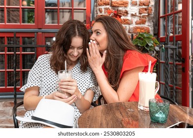 two young beautiful girls sitting in urban cafe with coffee and sharing secrets, girls party concept - Powered by Shutterstock