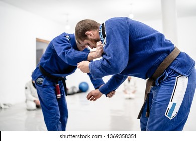 Two young BJJ Brazilian Jiu jitsu Athlete fighters training sparing technique at the academy fight