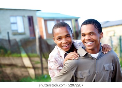 Two Young Black Boys Piggy Backing One Another.