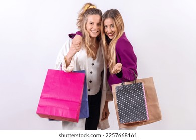 Two young blonde caucasian women, friends concept shopping on sales, paper bags - Powered by Shutterstock