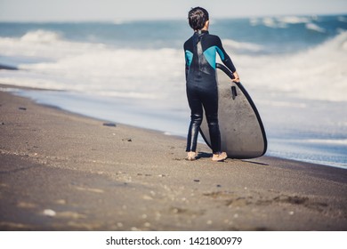 Two young boys having a beginner surf lesson and having fun in a sunny day in summer