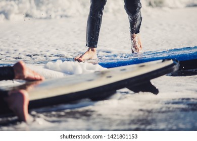 Two young boys having a beginner surf lesson and having fun in a sunny day in summer